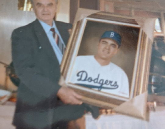 George Pfister holding a painting of himself as a Dodgers player (Courtesy of Sharon Pfister collection)