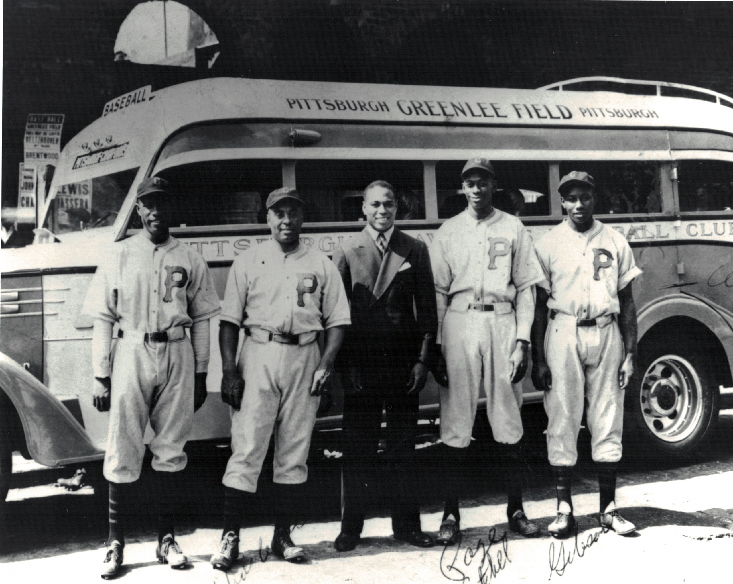 From left, Leroy Matlock, Oscar Charleston, boxer John Henry Lewis, Satchel Paige, and Josh Gibson pose in front of the team bus at Greenlee Field in Pittsburgh. (NOIRTECH RESEARCH, INC.)