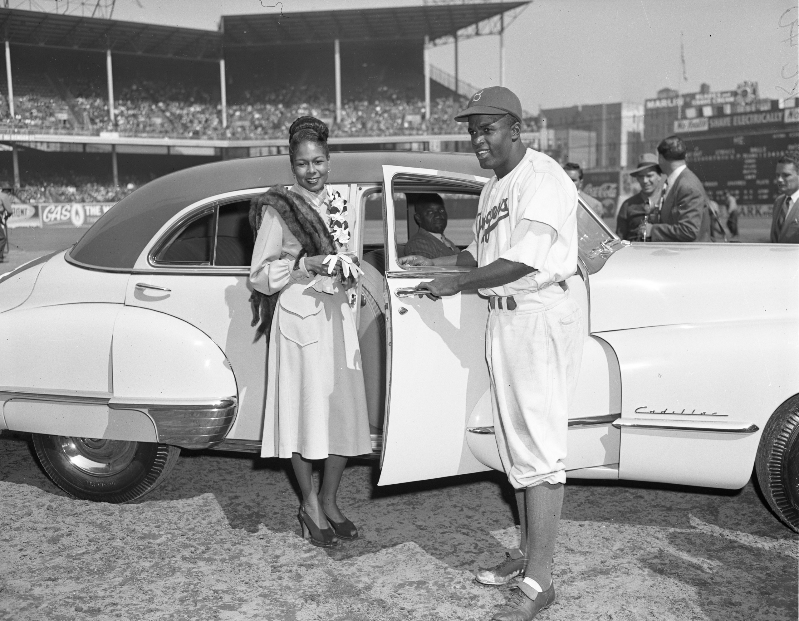 Jackie Robinson and his wife, Rachel, pose for photographs after a special award ceremony in Ebbets Field, where Robinson was given a new car on Jackie Robinson Day, September 24, 1947 in Brooklyn. (SABR-RUCKER ARCHIVE)
