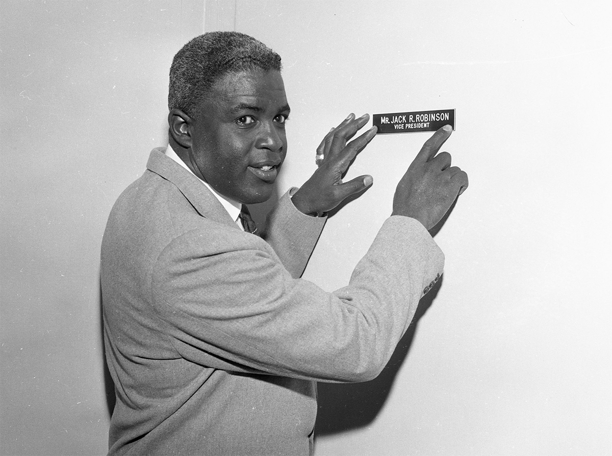 Jackie Robinson checks the name plate on his door as he begins work as Vice President at Chock Full O' Nuts company in New York in March 1957. (SABR-RUCKER ARCHIVE)