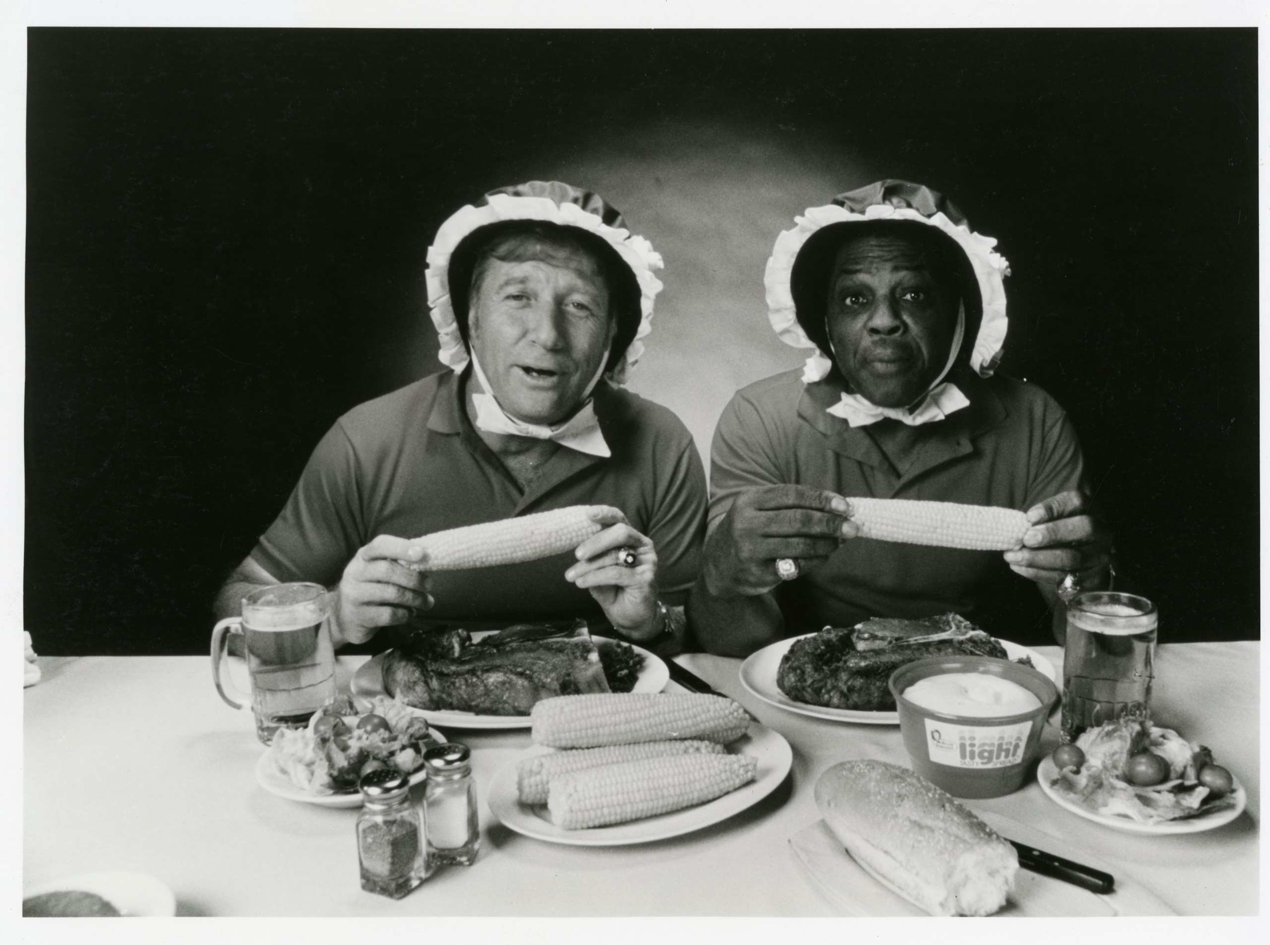 Mickey Mantle and Willie Mays in a 1980 Blue Bonnet margarine commercial posed wearing bonnets eating corn with a tub a margarine in the foreground. (National Baseball Hall of Fame Library)