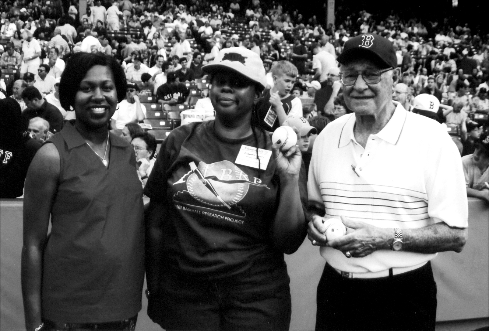 SABR Board President Claudia Perry, center, prepares to throw out the ceremonial first pitch at Fenway Park on June 28, 2002. At left is Boston Red Sox executive Marcita Thompson and at right is former Boston Braves player Sibby Sisti. (Courtesy of Bill Nowlin)