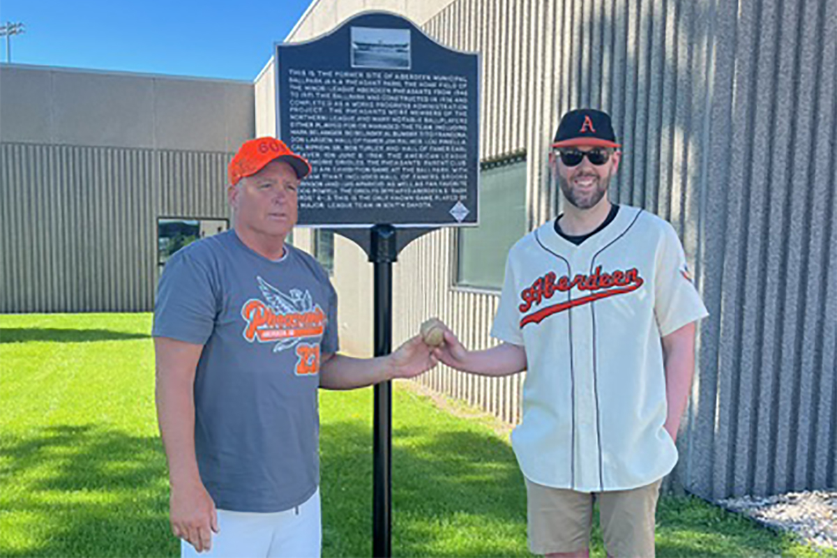 Bill Cantalope, left, and Ben Ernst stand by a new historical marker on the site of Aberdeen Municipal Stadium in South Dakota. Cantalope was a batboy when the Pheasants hosted the Baltimore Orioles in an exhibition game in 1964. (Courtesy of Ben Ernst)