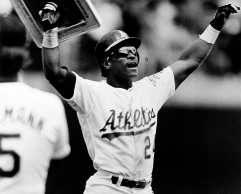 Rickey Henderson holds up a base after he broke Lou Brock's all-time career record for stolen bases on May 1, 1991 (SABR-Rucker Archive)